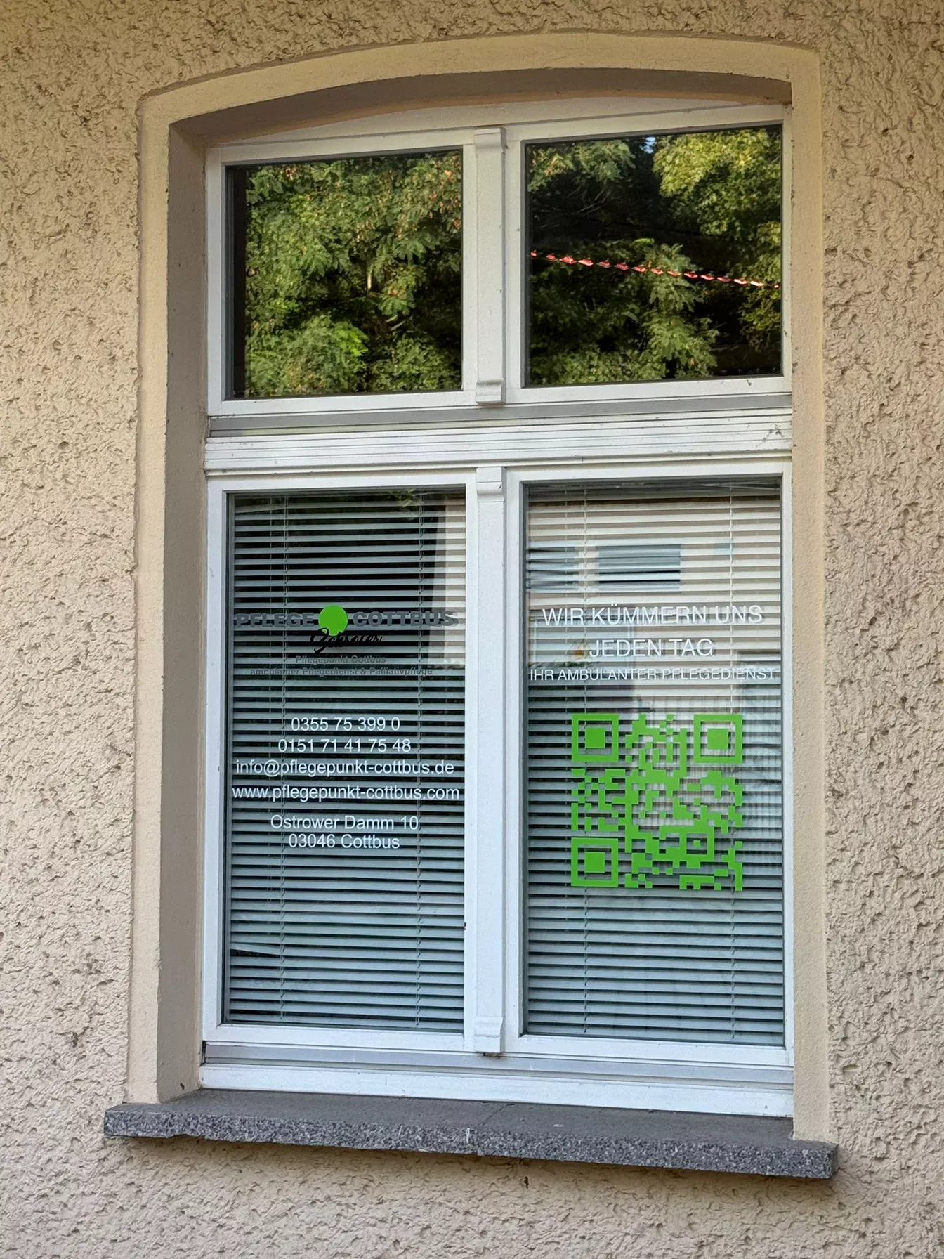 Umgesetzte Fensterbeschriftung mit Kontaktdaten und QR-Code für Pflegepunkt Cottbus